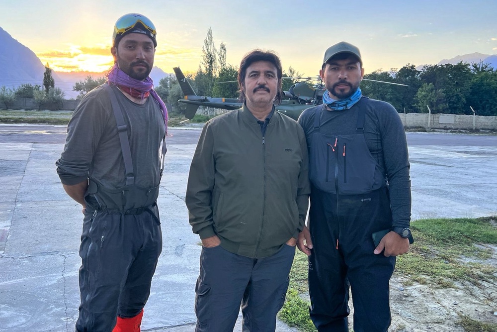 Members of a mountaineer rescue team pose for a photo with the honorary general secretary of Alpine Club of Pakistan, Ayaz Ahmed Shigri, centre, before departing from an airbase on a search operation for climbers missing after an avalanche on Pakistan’s Broad Peak, in Skardu (AP)