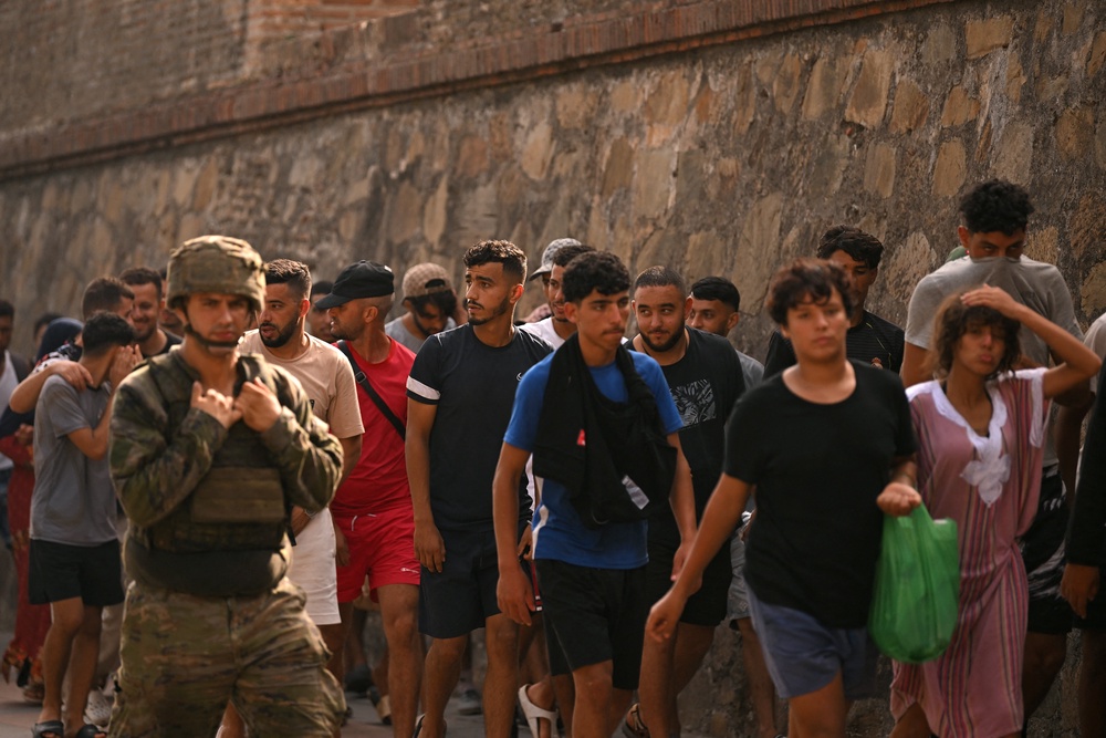A Spanish soldier escorting migrants to the Moroccan border (AFP/Getty)
