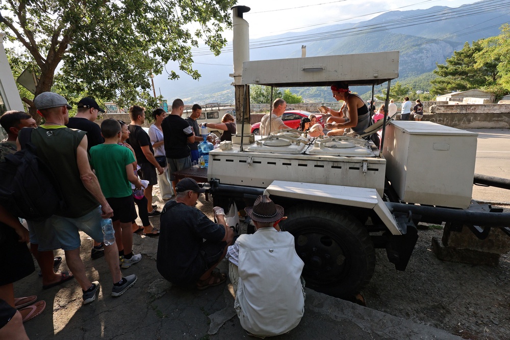 People line up for hot meals at a field kitchen set up by the local authorities in the settlement of Massandra, Crimea (Reuters)