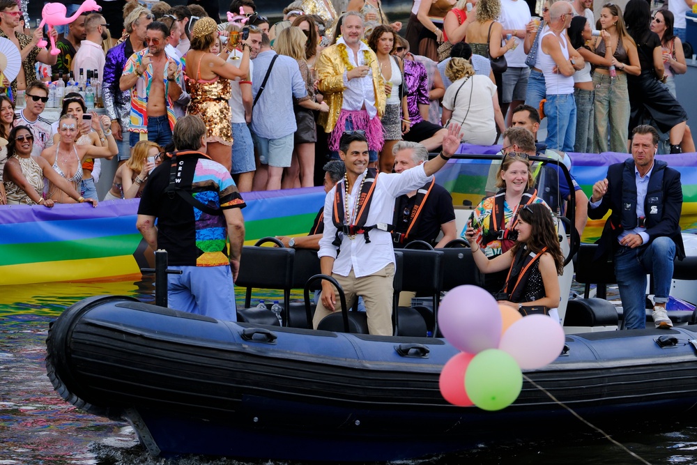 Openly gay Dutch Prime Minister Rob Jetten, dressed in a white shirt, black life vest and gold necklace, waved to crowds as he sailed in a small boat through the colorfully decorated parade of 80 vessels (AP)