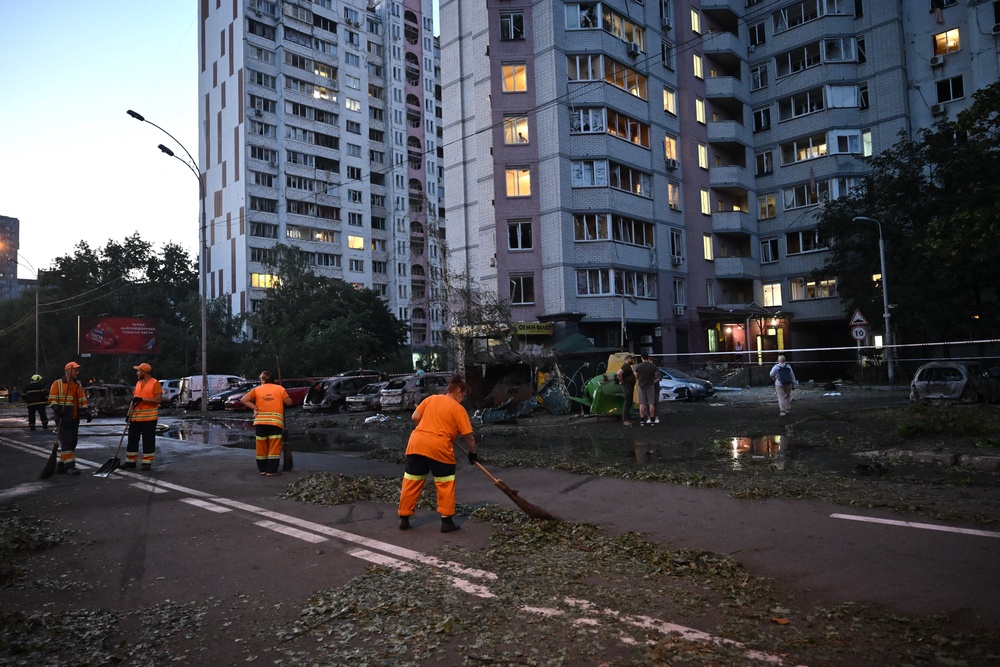 Communal workers clear trash outside a multi-storey residential building damaged following massive Russian ballistic missile strikes in the Ukrainian capital of Kyiv (AFP/Getty)