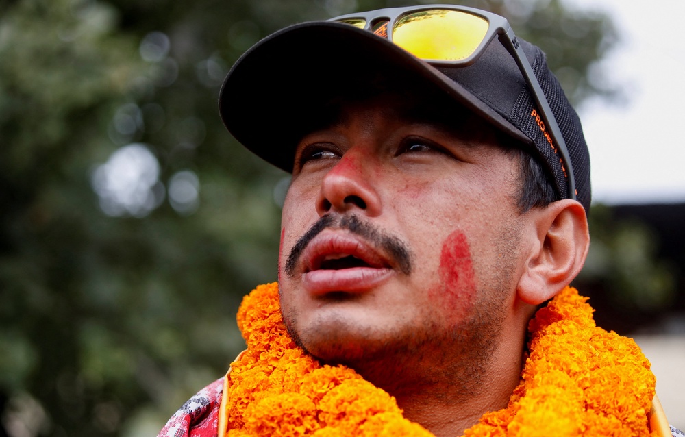 Nirmal Purja, who became the fastest person to summit the world's 14 highest mountains, speaks with the media upon his arrival at Tribhuvan International Airport in Kathmandu, Nepal (Reuters)
