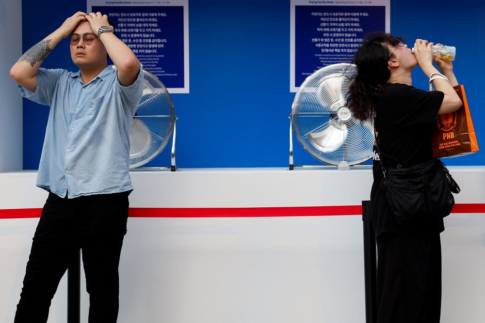 People cool off in front of fans during a heatwave in Seoul (Reuters)