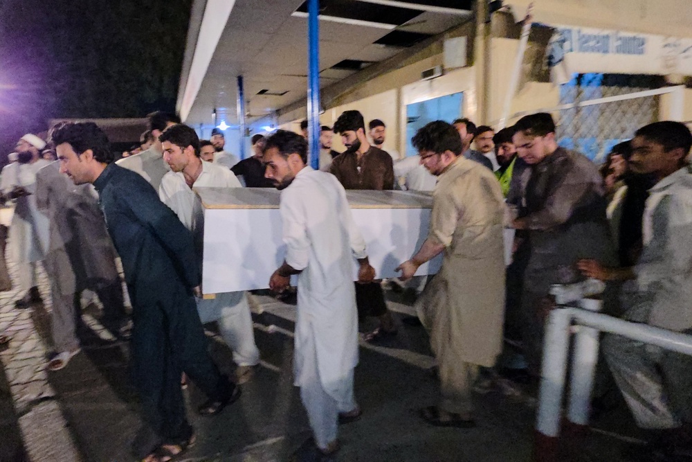 People carry a casket of a victim of suicide bombing, to transport after collecting from a hospital (AP)