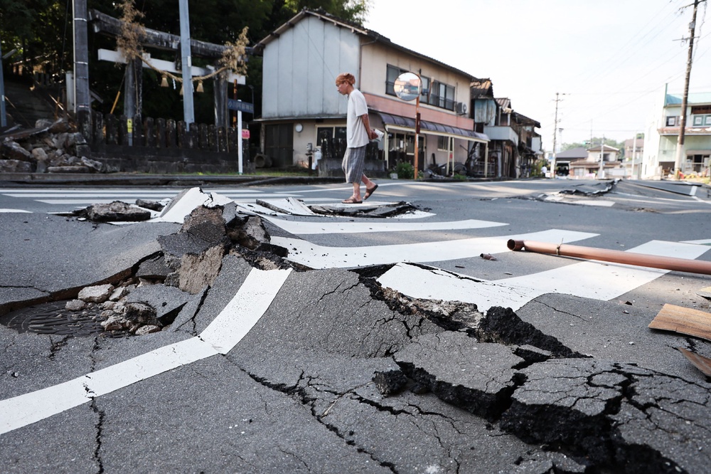 Un hombre camina por una carretera destruida en Uki, prefectura de Kumamoto. (AFP/Getty)