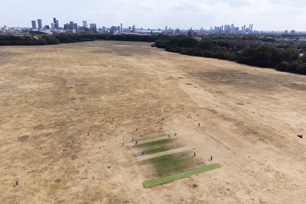 Cricketers play on small patches of green grass surrounded by scorched earth at Hackney Marshes, east London (Ben Whitley/PA) (PA Wire)
