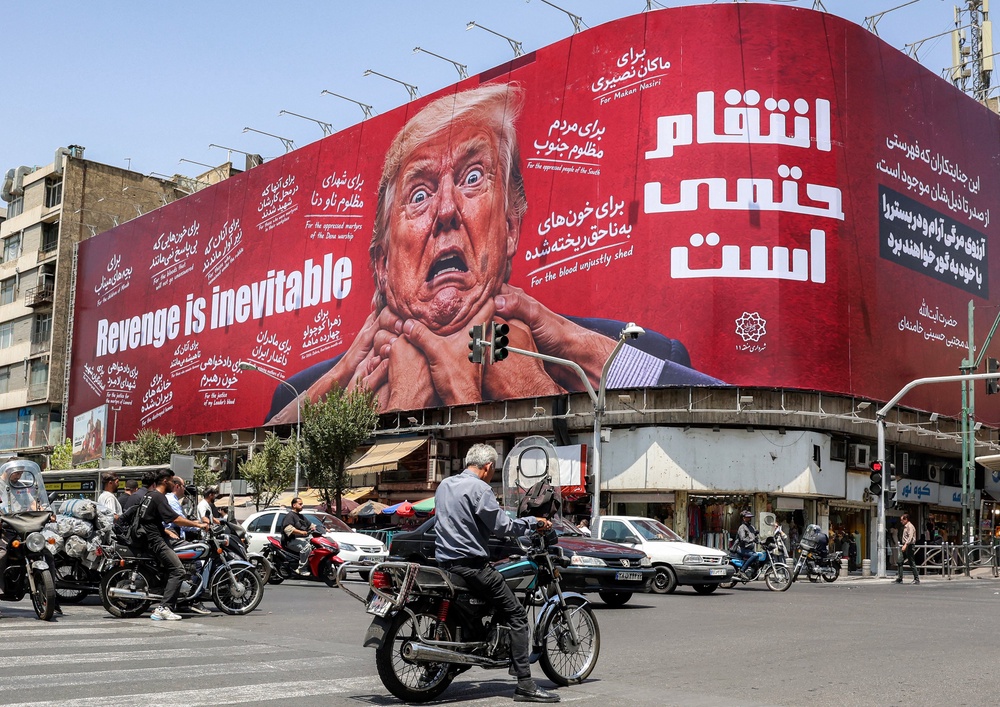 Iran’s acting defense minister accused the US of 'psychological and cognitive warfare,' according to a state media post on X. Pictured: Motorists in Tehran drive past a large billboard pledging revenge against Trump on July 27 (AFP via Getty Images)