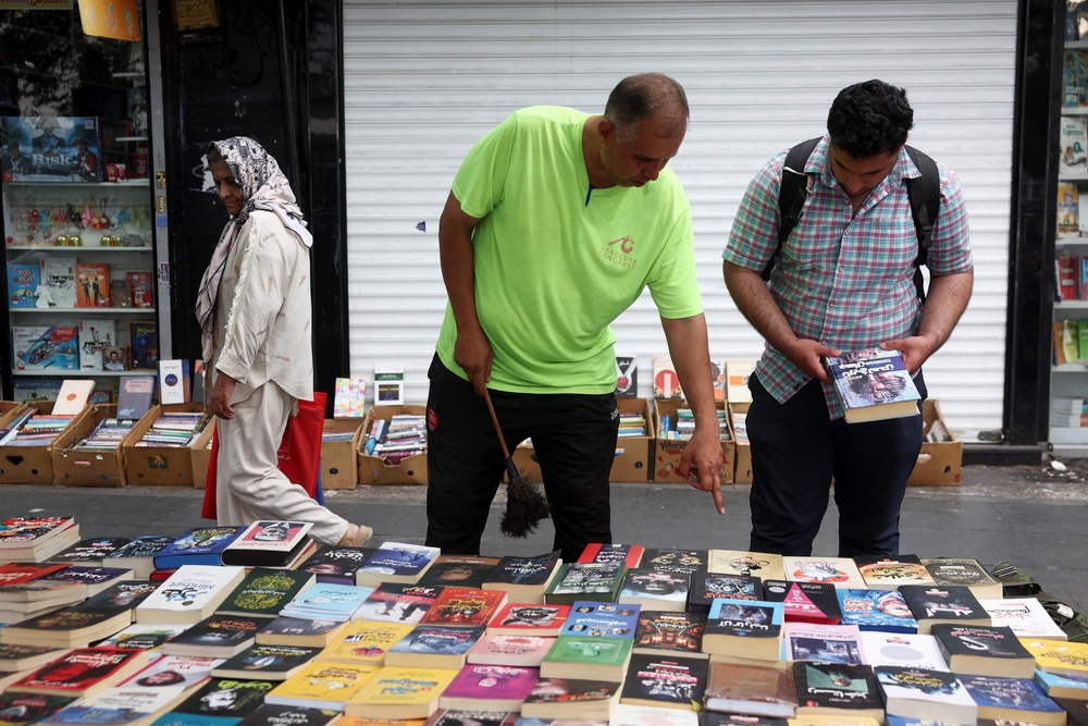 A person looks at books on a street in Tehran (Reuters)