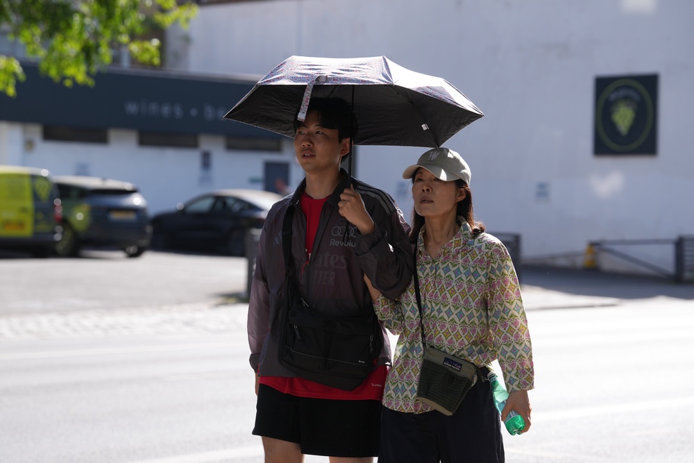 People sheltering themselves from the sun in London (Maja Smiejkowska/PA) (PA Wire)
