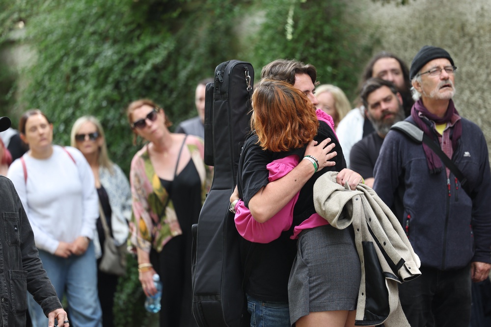 People hug while queueing for the public wake (Damien Eagers/PA) (PA Wire)