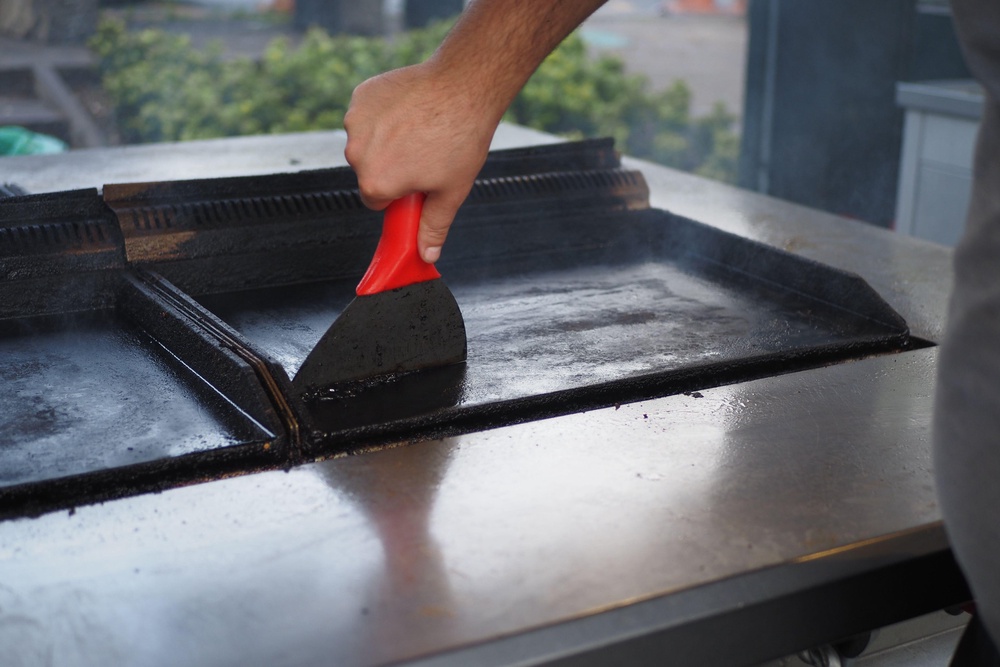The food and any built-up gunk on your grill will come away so much quicker and easier if your grill is hot (Alamy/PA)