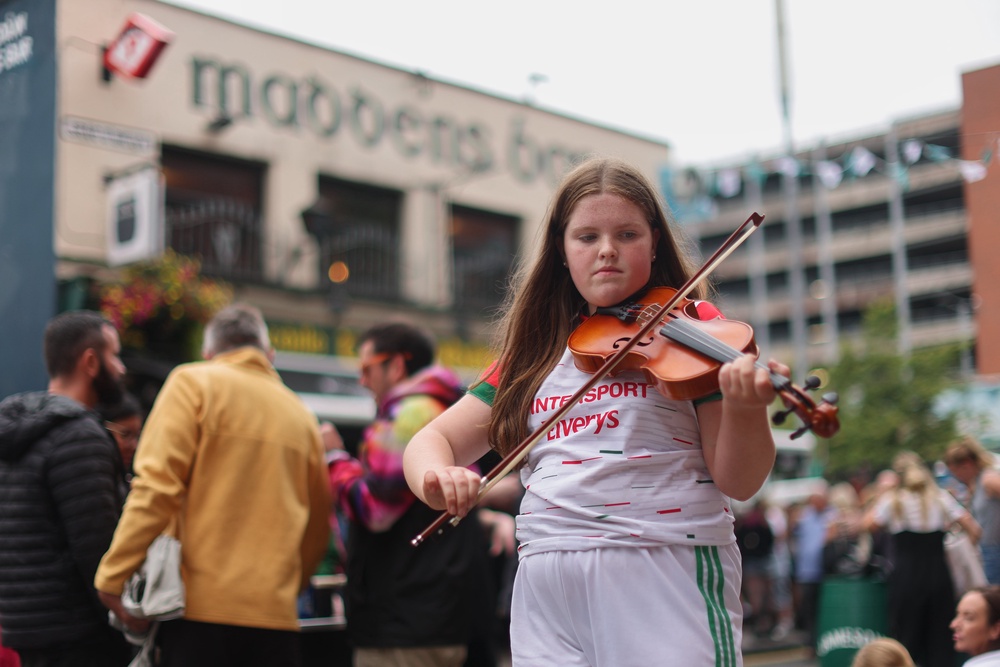 Tara McNeill, 12, playing the fiddle with the Glengormley School of Music outside Madden’s Bar (Liam McBurney/PA) (PA Wire)