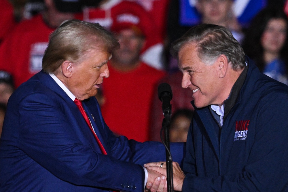 Former US President and Republican presidential candidate Donald Trump shakes hands with US Senate candidate Mike Rogers (AFP/Getty)