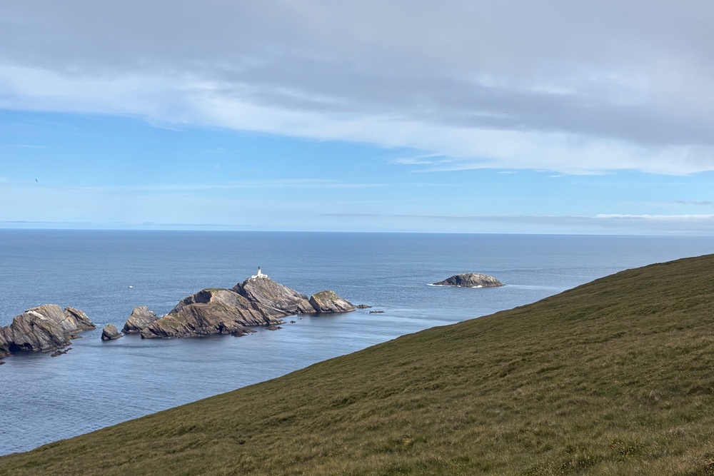 Muckle Flugga lighthouse (L) and Out Stack, the northernmost point in the British Isles (R) (Amelia Neath/The Independent)