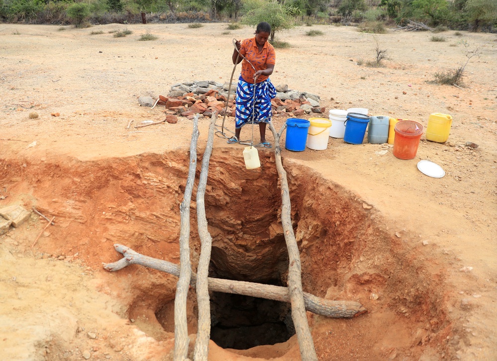 A woman fetches drinking water from an unprotected well, as Zimbabwe is experiencing an El Nino-induced drought. (Reuters)