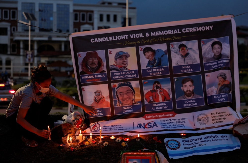 Dawa Chhinzum Sherpa, daughter of Kili Pemba Sherpa, who died in an avalanche while summiting Broad Peak in Pakistan, offers a candle during a vigil to honour climbers, including celebrated British-Nepali climber Nirmal Purja, also known as Nimsdai, in Kathmandu, Nepal, 4 August 2026 (Reuters)