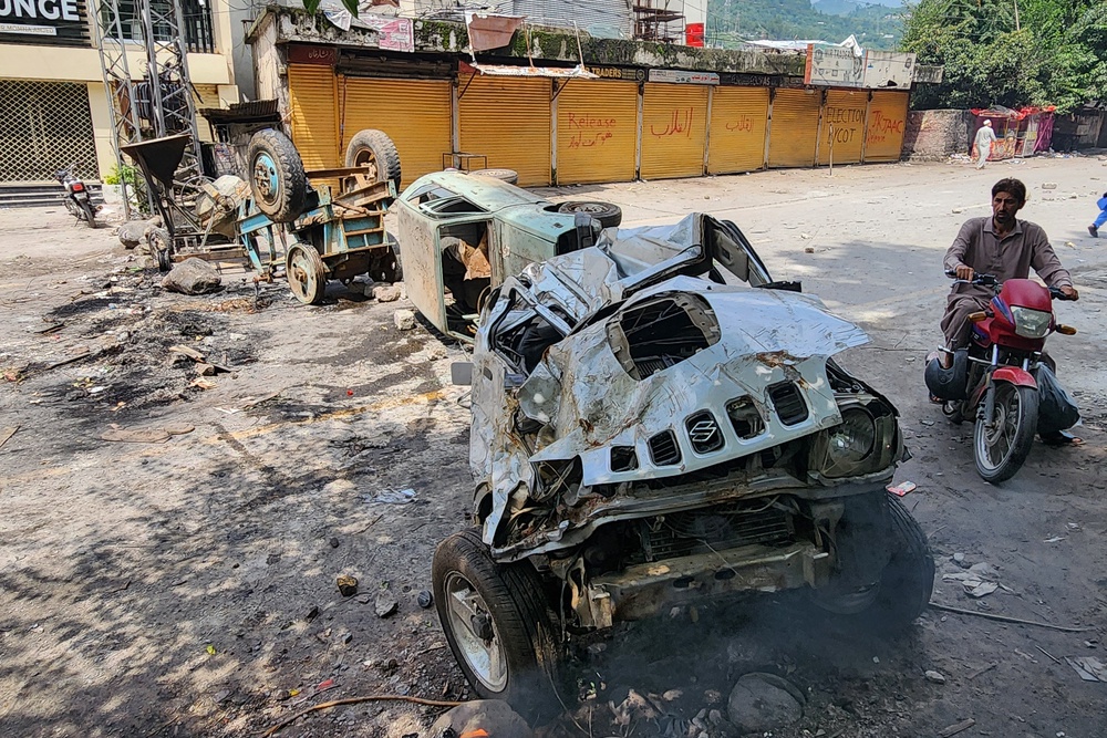 A motorcyclist rides along a blocked road following clashes between protesters and security personnel in Muzaffarabad on 1 August 2026 (AFP/Getty)