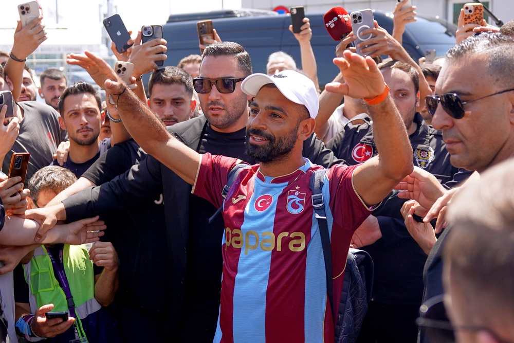 Egypt's Mohamed Salah wearing his new Trabzonspor team jersey gestures to supporters as he arrives at the airport in Istanbul (AP)