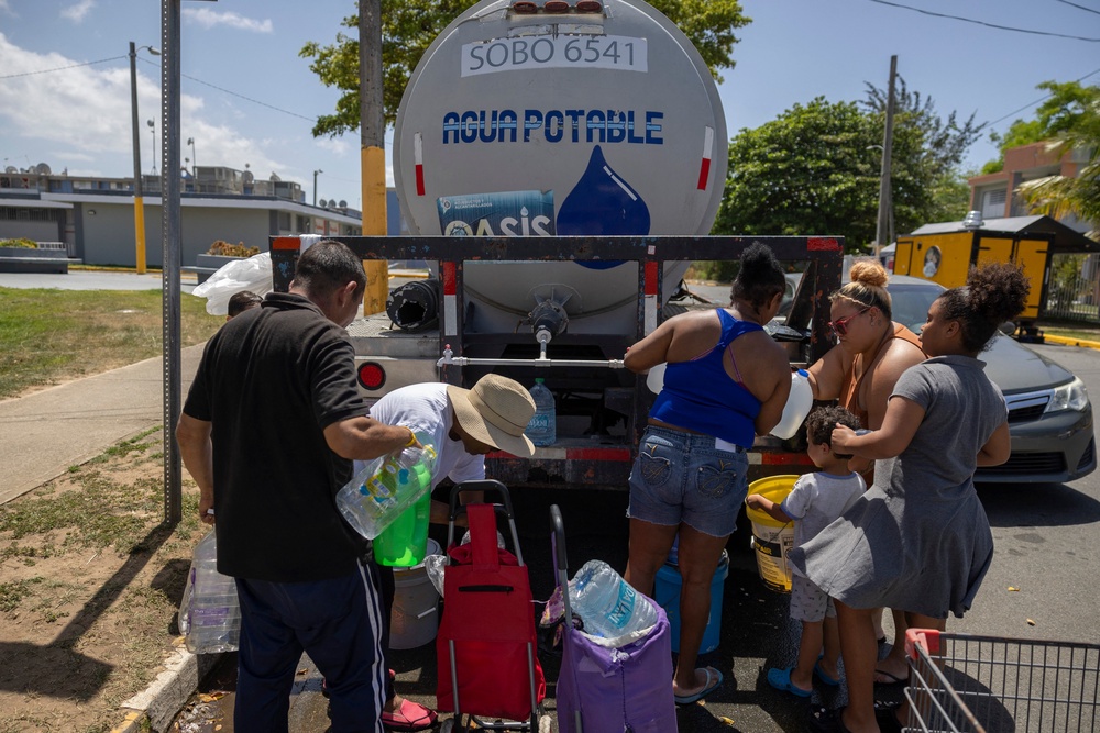 Residents collect drinking water from a tanker truck at an emergency water distribution point (AFP via Getty Images)