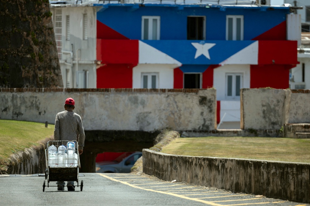 A man transports water containers amid ongoing water shortages in Old San Juan, Puerto Rico (AFP via Getty Images)