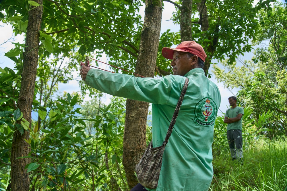 A farmer uses a slingshot while guarding crops from monkeys in Dharamghar, Dolakha district, about 86 kilometers (53 miles) east of Kathmandu, Nepal, Friday, July 24, 2026 (Copyright 2026 The Associated Press. All rights reserved.)