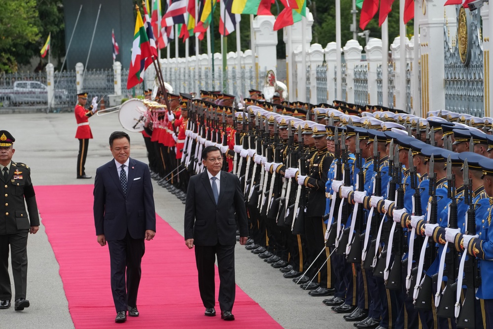 Anutin Charnvirakul, centre left, and Min Aung Hlaing review an honor guard during a welcome ceremony in Bangkok (AP)