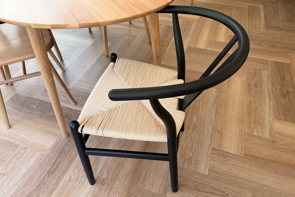 It’s made from beech wood with a brooding black finish and natural rope seat (Emily Peck/The Independent)