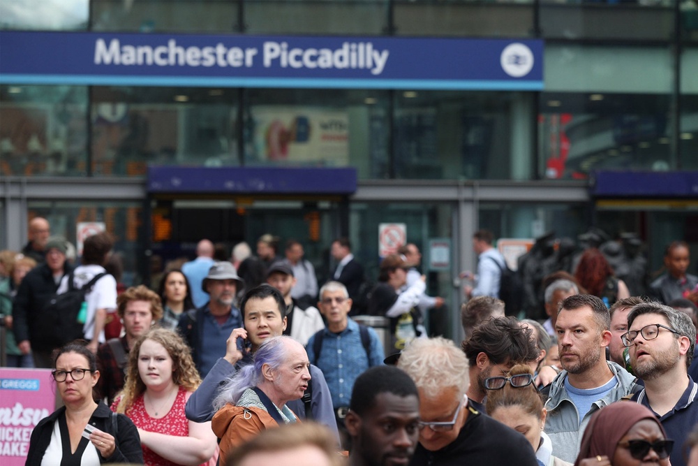 Passengers gather outside Manchester Piccadilly train station after a major disruption to rail service (Getty)