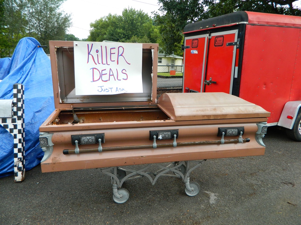 A roadside sign propped inside an open casket promises a ‘killer deal’ along a 700-mile stretch of rural back roads (127 Yard Sale)