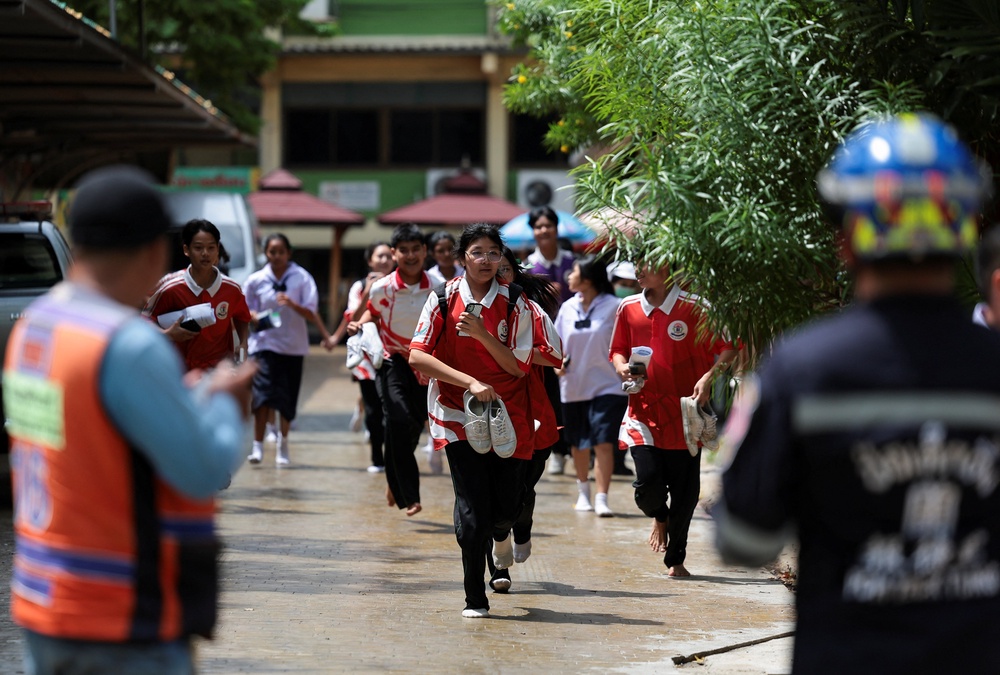 Students run as they evacuate from Debsirin Nonthaburi School, the site of a shooting incident, in Bang Kruai district (Reuters)