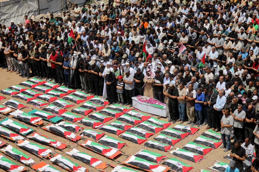 Mourners stand near bodies wrapped in Palestinian flags during a mass funeral in Gaza City, Gaza Strip, (AFP/Getty)