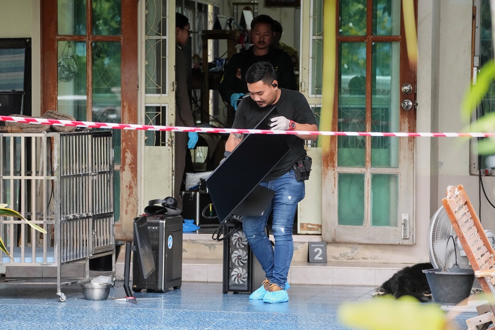 Police take away computers from the home of a student who shot several people (AP)