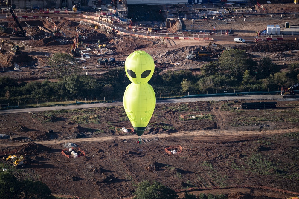 An alien hot air balloon floats high above the ground (Ben Birchall/PA) (PA Wire)