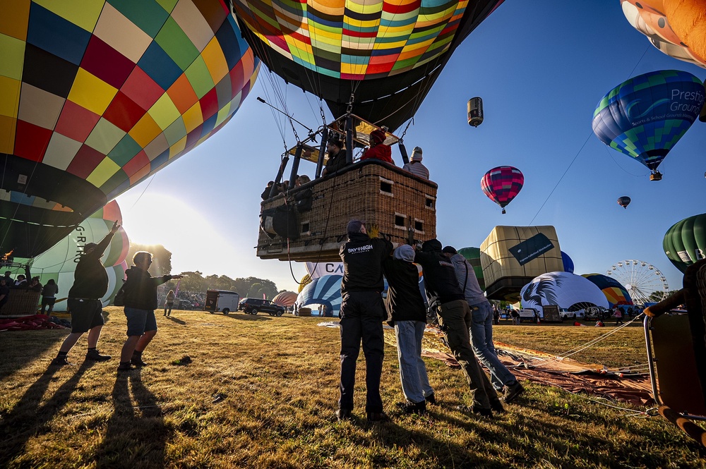 Crews push hot air balloons into position before lift-off (Ben Birchall/PA) (PA Wire)