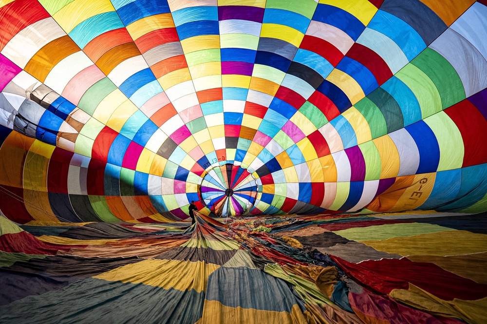 A pilot checks internal rigging inside one colourful balloon (Ben Birchall/PA) (PA Wire)