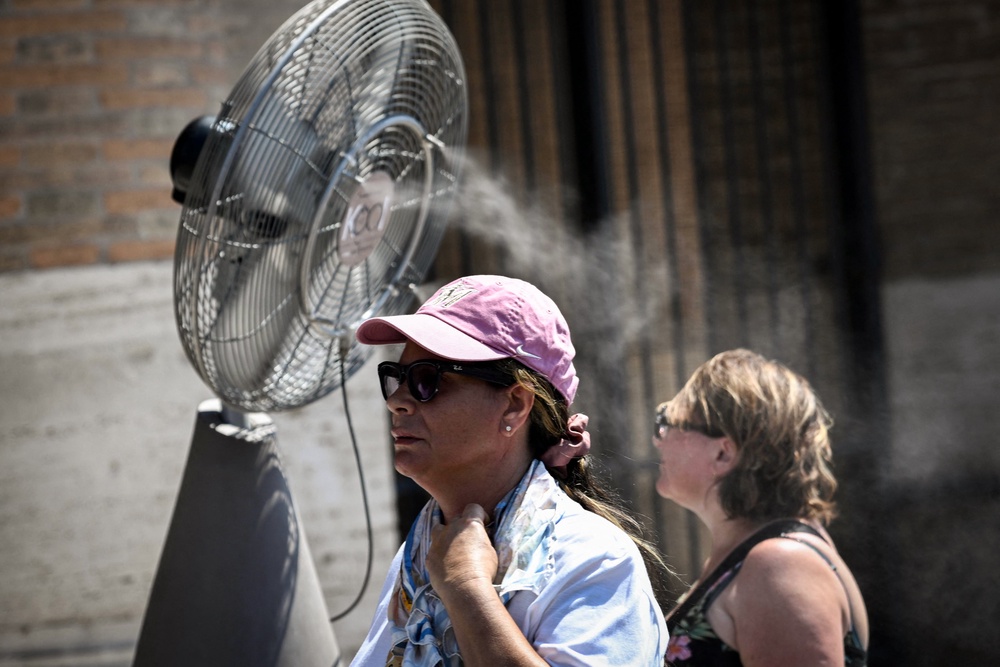 People walk past a misting fan during a heatwave in Rome at the Colosseum, on 6 August 2026 (AFP/Getty)