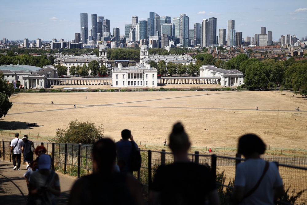 People walk on a path between the sun scorched grass, turned yellow-brown by a lack of rain, in Greenwich Park (AFP/Getty)