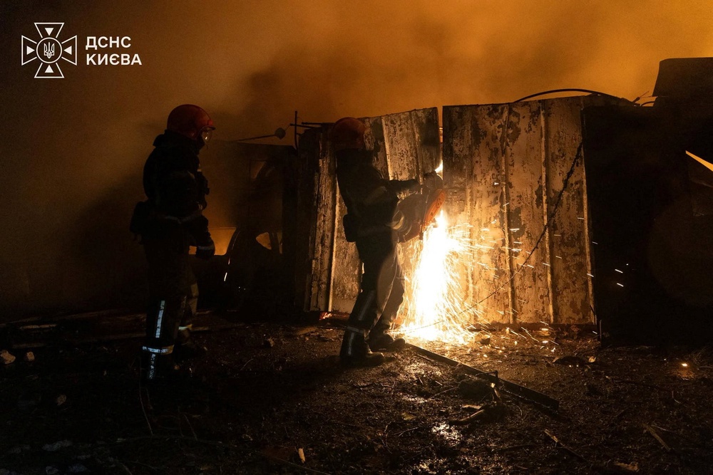 Firefighters work to douse fire at a car garage damaged during overnight Russian missile strikes (Reuters)