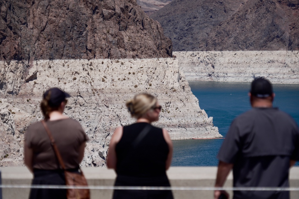 Tourists on the Hoover Dam look out at the bathtub ring of minerals that shows the former water levels of Lake Mead near Boulder City, Nevada