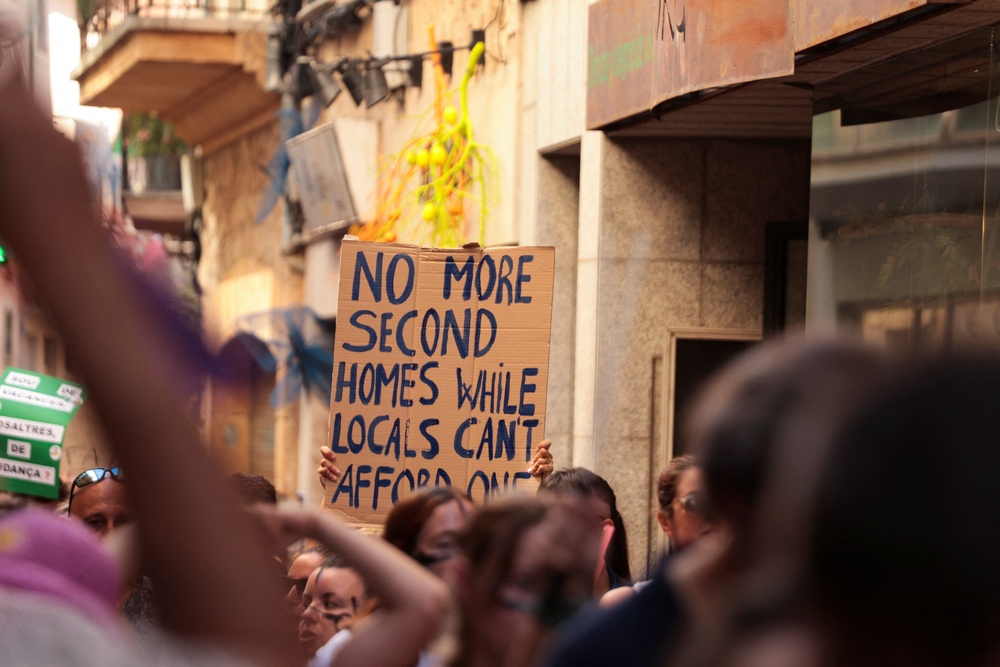 A demonstrator holds a sign during a protest against mass tourism and gentrification in the Balearic Islands, in Soller, Mallorca, Spain (Reuters)
