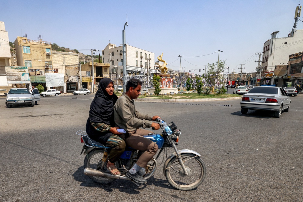 A woman rides behind a man on a motorcycle in Minab in Iran's southern Hormozgan province on August 10 (AFP/Getty)