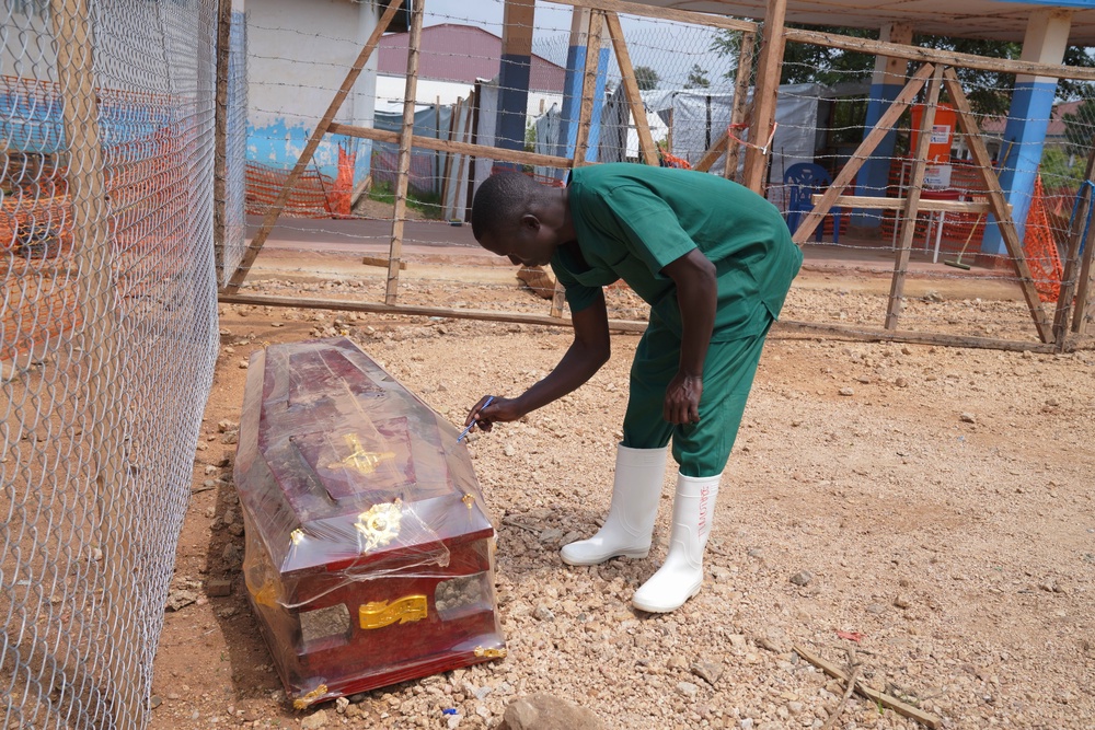 A health worker on the dignified and safe burial team monitors a casket (Copyright 2026 The Associated Press. All rights reserved.)