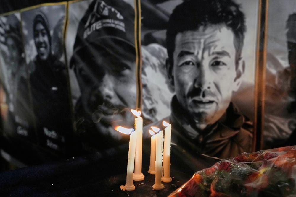 Candles burn next to pictures of climbers who lost their lives on Broad Peak (AP Photo/Anjum Naveed)