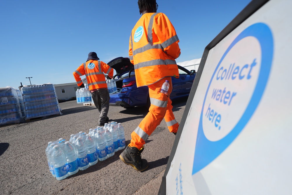 Thames Water personnel handing out bottled water to residents (Yui Mok/PA) (PA Wire)