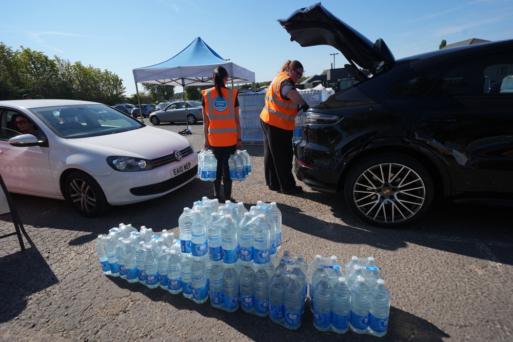 Thames Water personnel handed out bottled water to residents at Roding Sports Centre in Chigwell, Essex (Yui Mok/PA) (PA Wire)