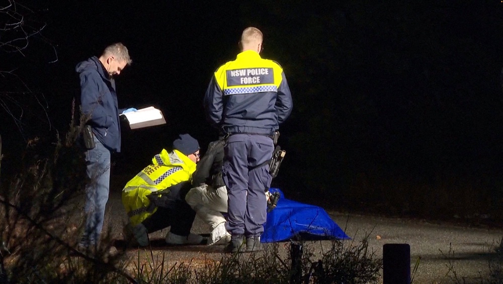Police personnel handle a bag covered in plastic containing a lifelike doll (Reuters)