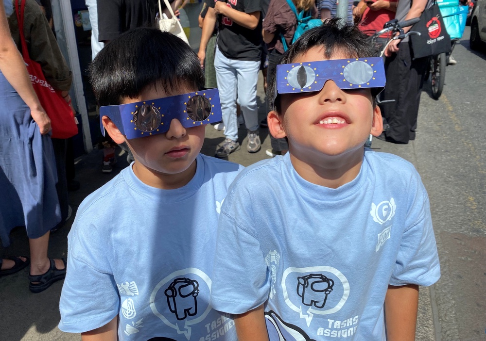 Seven-year-old twins Faron and Soren Walshe with their glasses in George's Street in Dublin to watch the eclipse on 12 August, 2026 (PA)