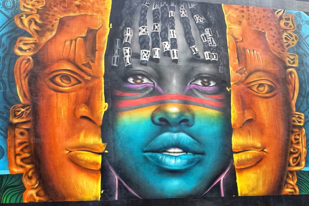 A mural shows an ancient mask splitting open to reveal a teenage girl at Marina Boulev’art (Phil Thomas)