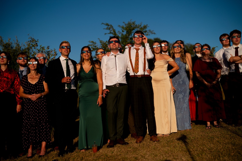TWedding guests watch the solar eclipse at Alpheton in Suffolk (PA)