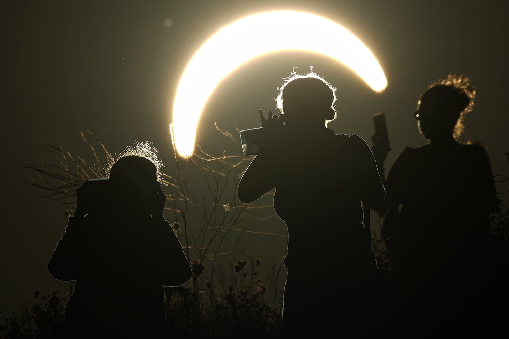 People observe a partial solar eclipse at Northala Fields in London (AP Photo/Frank Augstein)